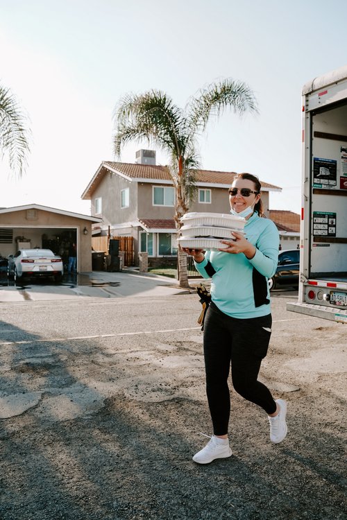 Woman holding three platters of food